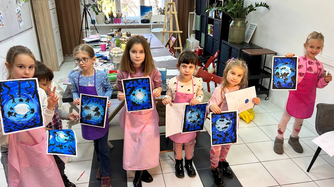 Children at the studio holding their blue moonlight paintings